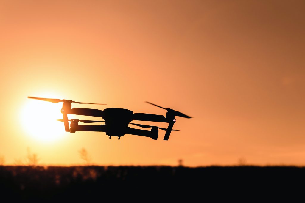 Drone flying over fields at sunset